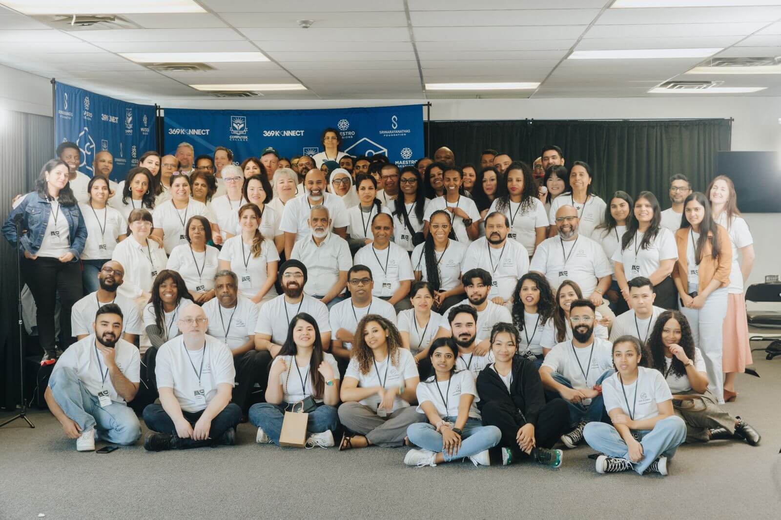 Group photo of 369 Global employees wearing white shirts, showcasing commitment to living wages and employee welfare amidst rising living costs in Canada.