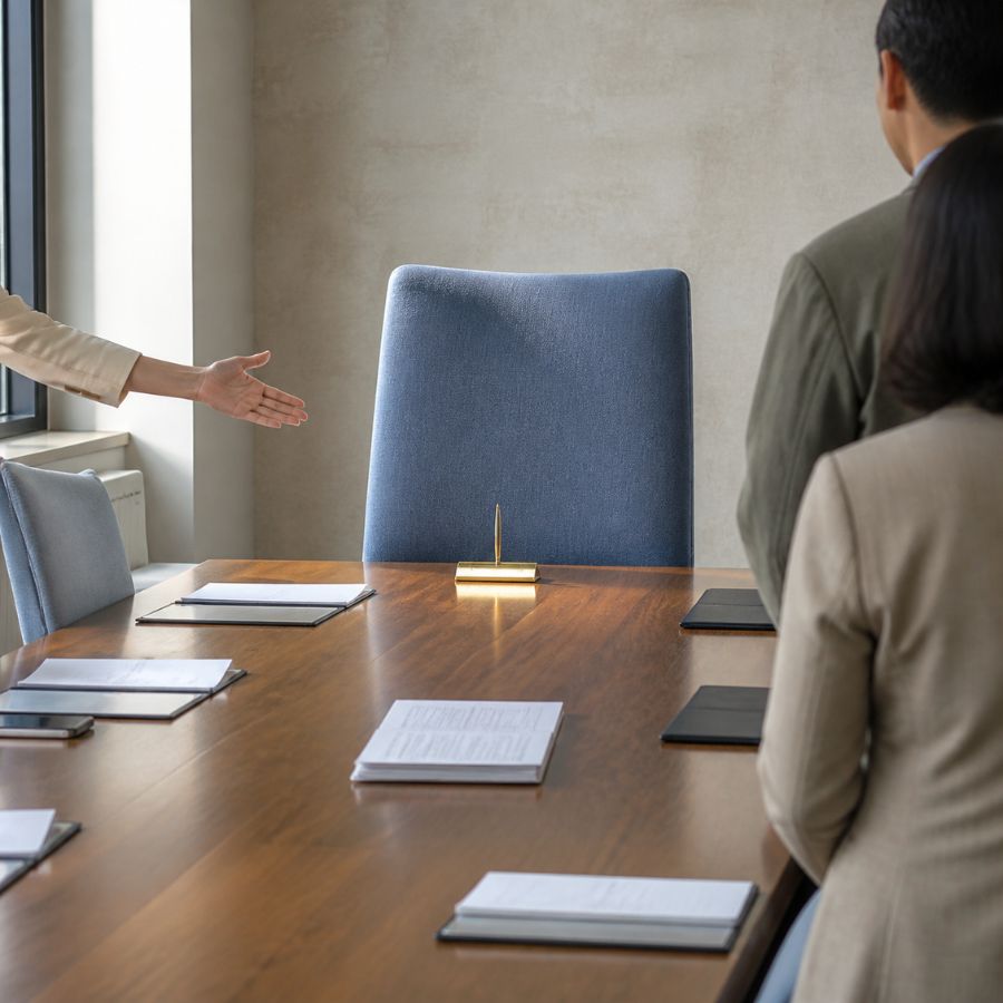 Empty blue conference chair at a polished wood table, symbolizing the need for cultural understanding